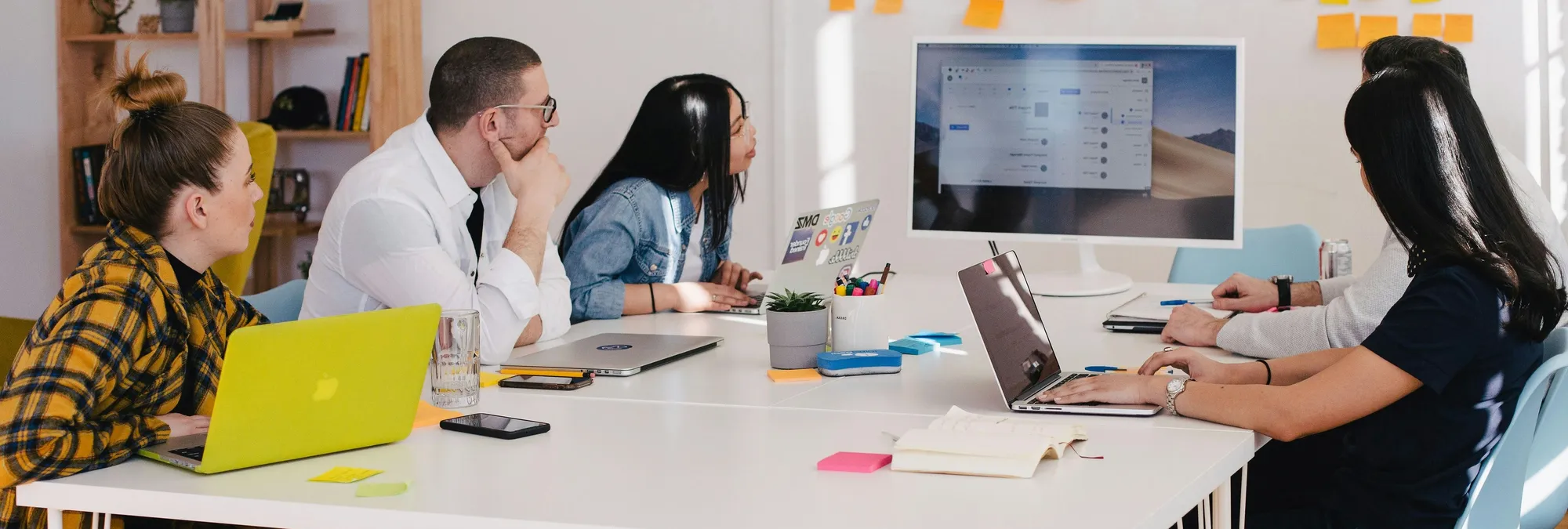 Formation dans une salle de réunion ou 5 personnes regardent un écran